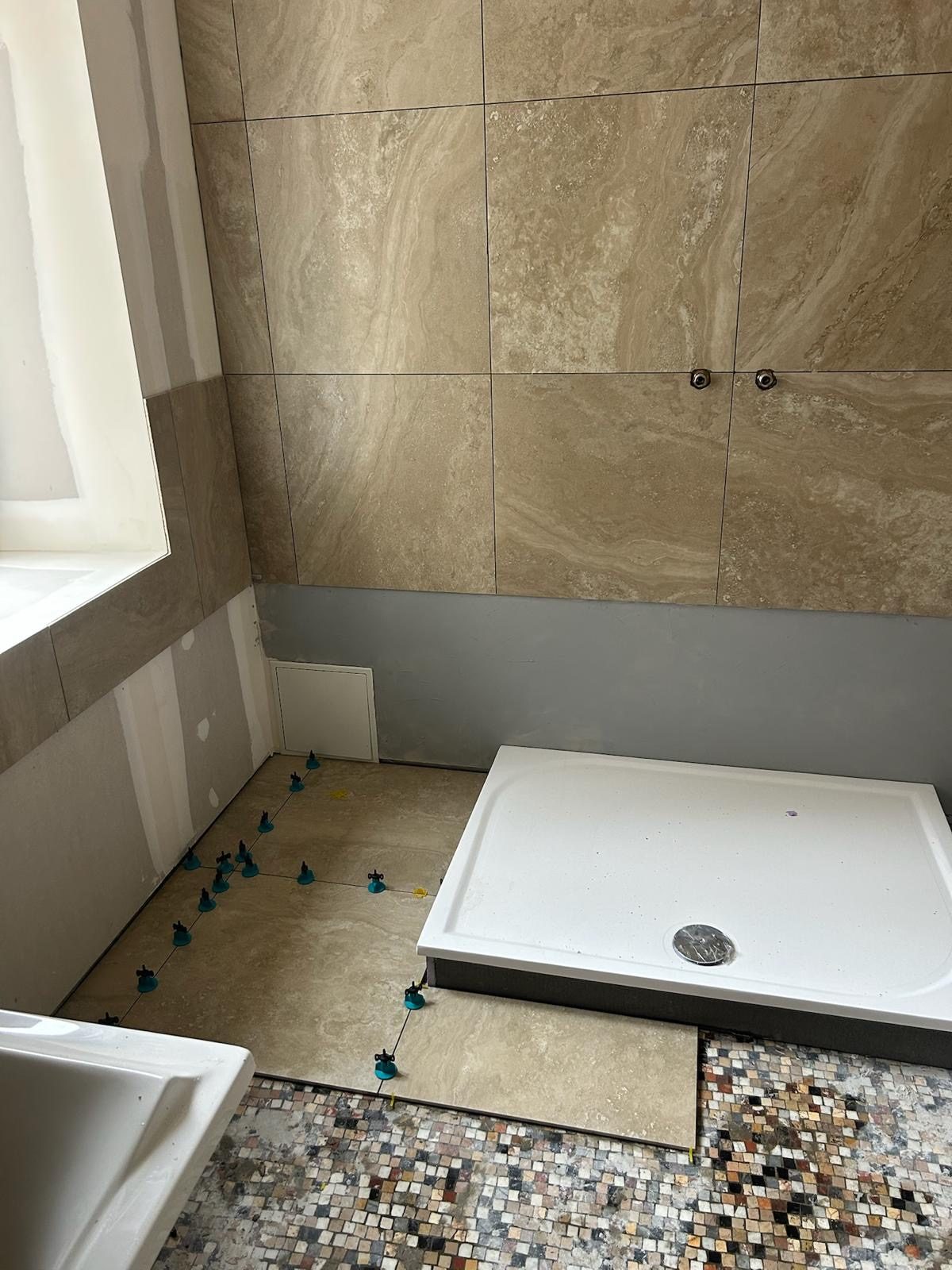 Receveur de douche calé et pose du carrelage au sol en cours
