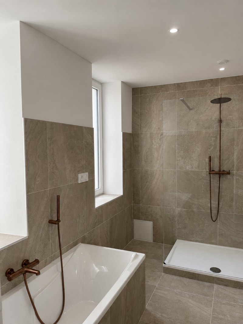 Après : baignoire et douche à l’italienne, carrelage grand format posé par Carpentier.